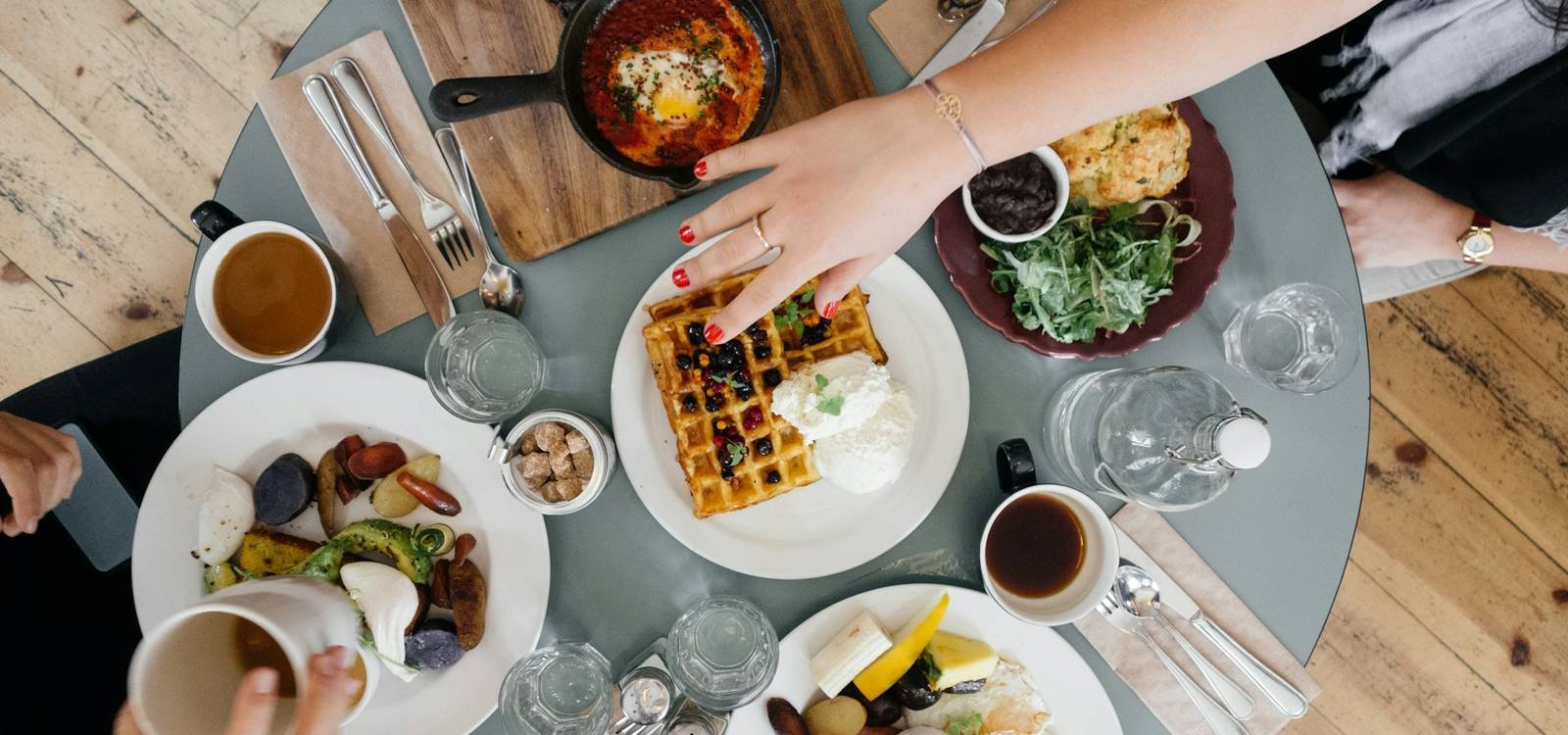 Friends sharing dishes around a table, seen from above