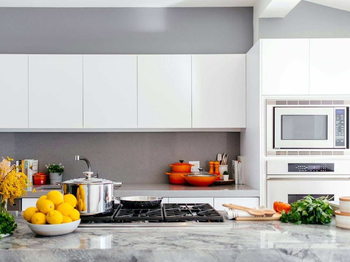 A spotless white kitchen with a clear worktop